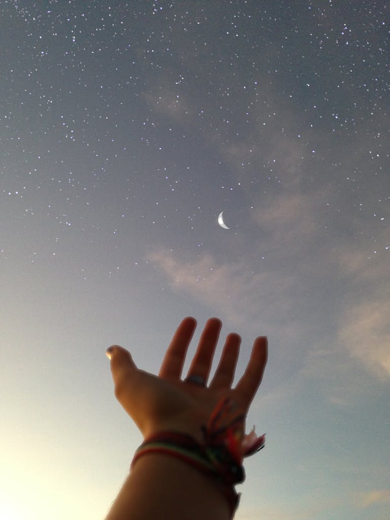 Person's Hand Reaching for the Sky